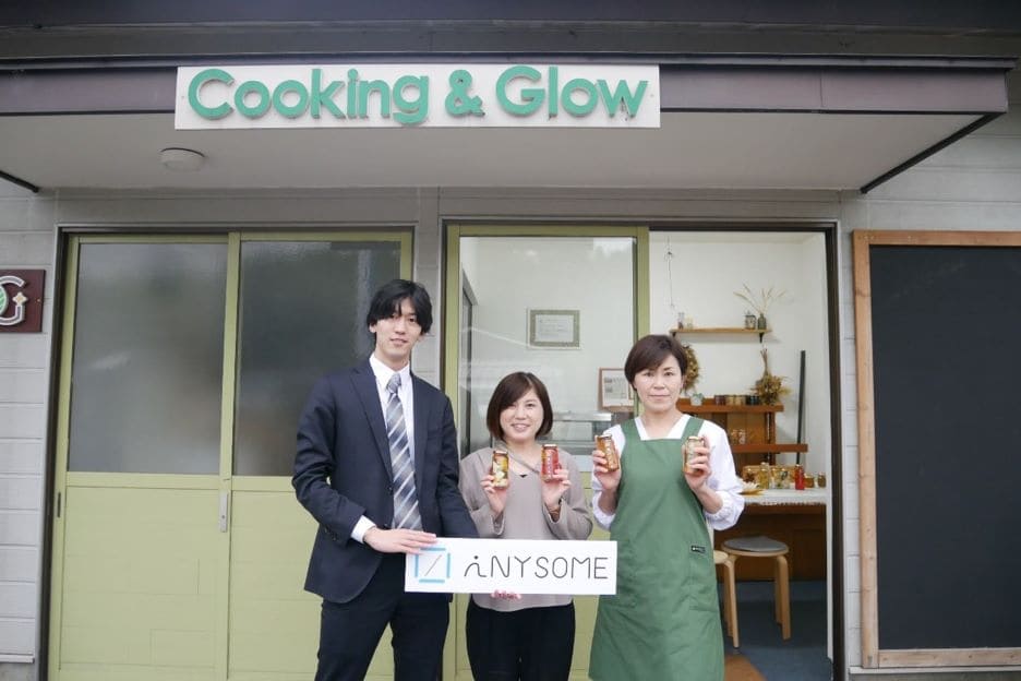 株式会社Cooking&Glowの前にて本間、金原氏、 釡井氏3人が並んだ写真